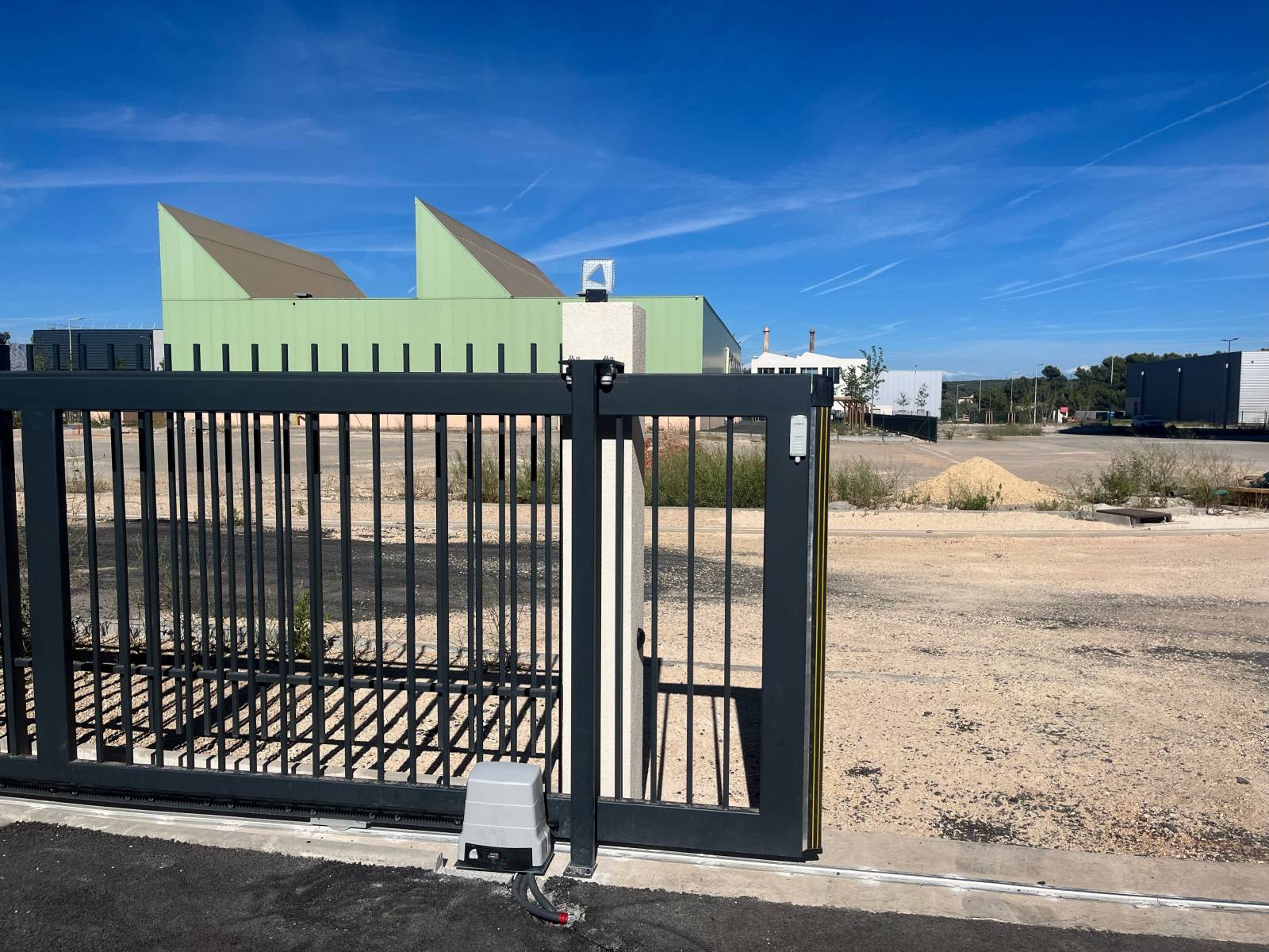 Installation d'une motorisation sur un portail coulissant industriel à Bouc Bel Air pour une entreprise de menuiserie.